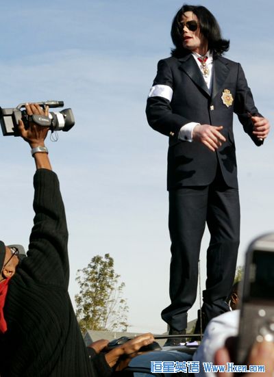 Michael Jackson stands on his car to wave to fans after leaving the courthouse where he was arraigned in Santa Maria, California in this January 16, 2004 file photo. (Xinhua/Reuters Photo)