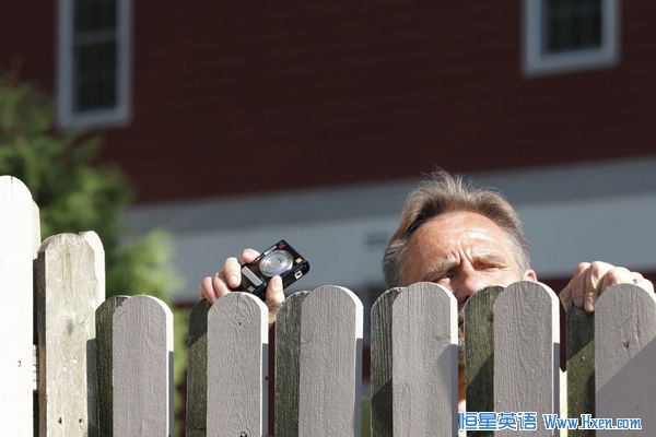 A spectator peeks over a fence as he tries to look at guests departing for Chelsea Clinton's wedding in Rhinebeck, New York July 31, 2010. (Xinhua/Reuters Photo)