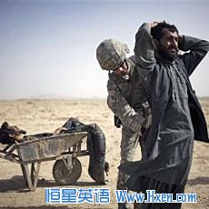 A US Army soldier searches an associate of a suspected Taliban IED placer, seen in a wheelbarrow, who was killed in a coalition missile strike in Zhari district, Kandahar province (File)