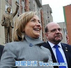 U.S. Secretary of State Hillary Rodham Clinton smiles in front of a statue of her husband former President Bill Clinton, in Pristina, Kosovo, 13 Oct. 2010