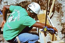 Student Fladimir Celunice checks to make sure his installation is level.