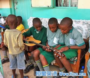 Children at the Divine Providence Children's Home in Kakamega, Kenya, examine a guitar.